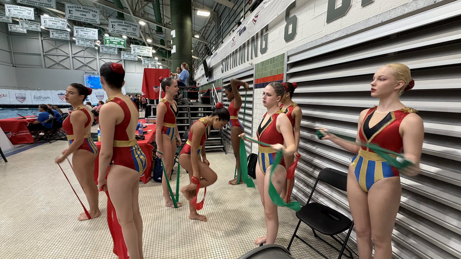 The team warming up with resistance bands on the deck at a meet